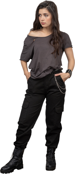 Front view of a female rocker putting hands in pockets while looking aside