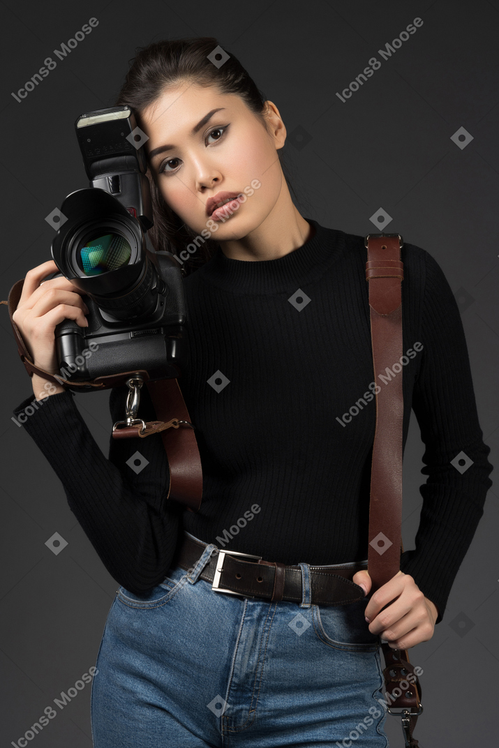 Young beautiful woman posing with a camera