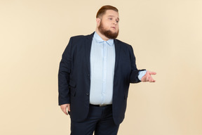 Young overweight man in suit trying to figure out something