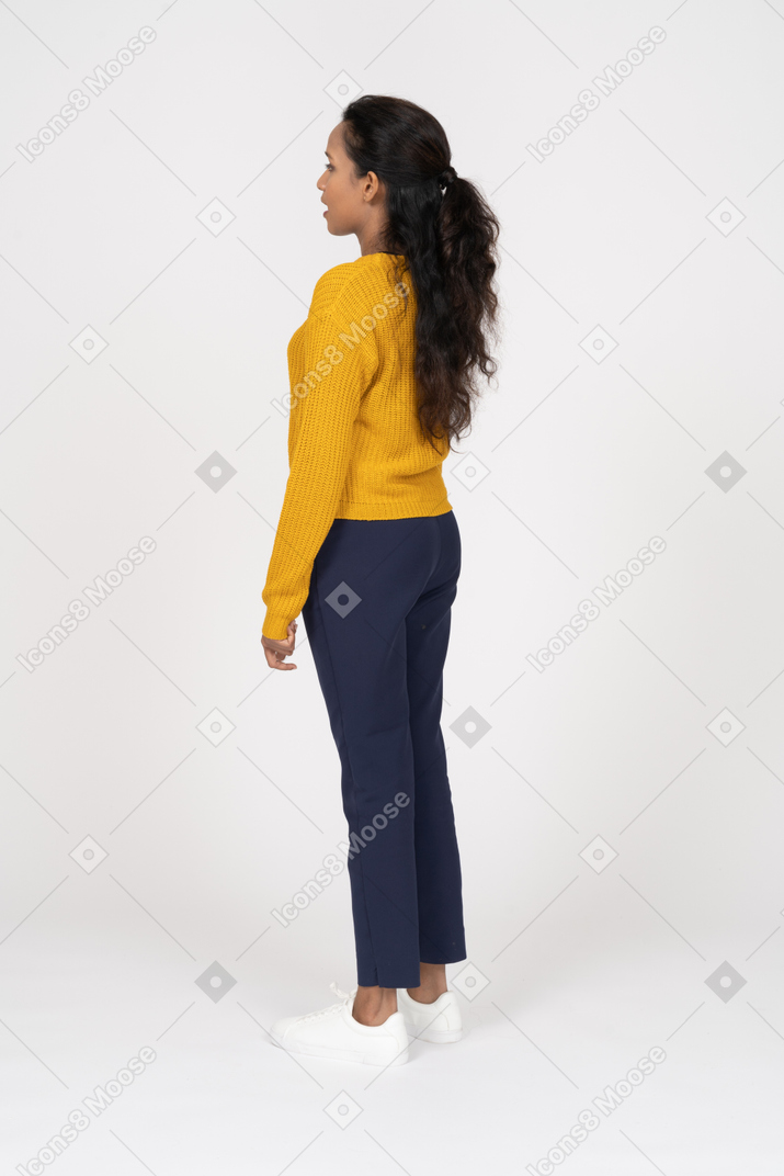 Vista lateral de uma garota com roupas casuais em pé com a boca aberta