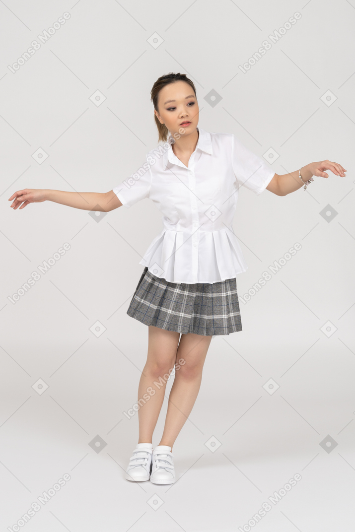 Азиатская молодая женщина склоняется в стороны с широко расставленными руками