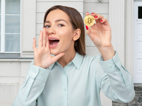 Woman holding bitcoin and whispering