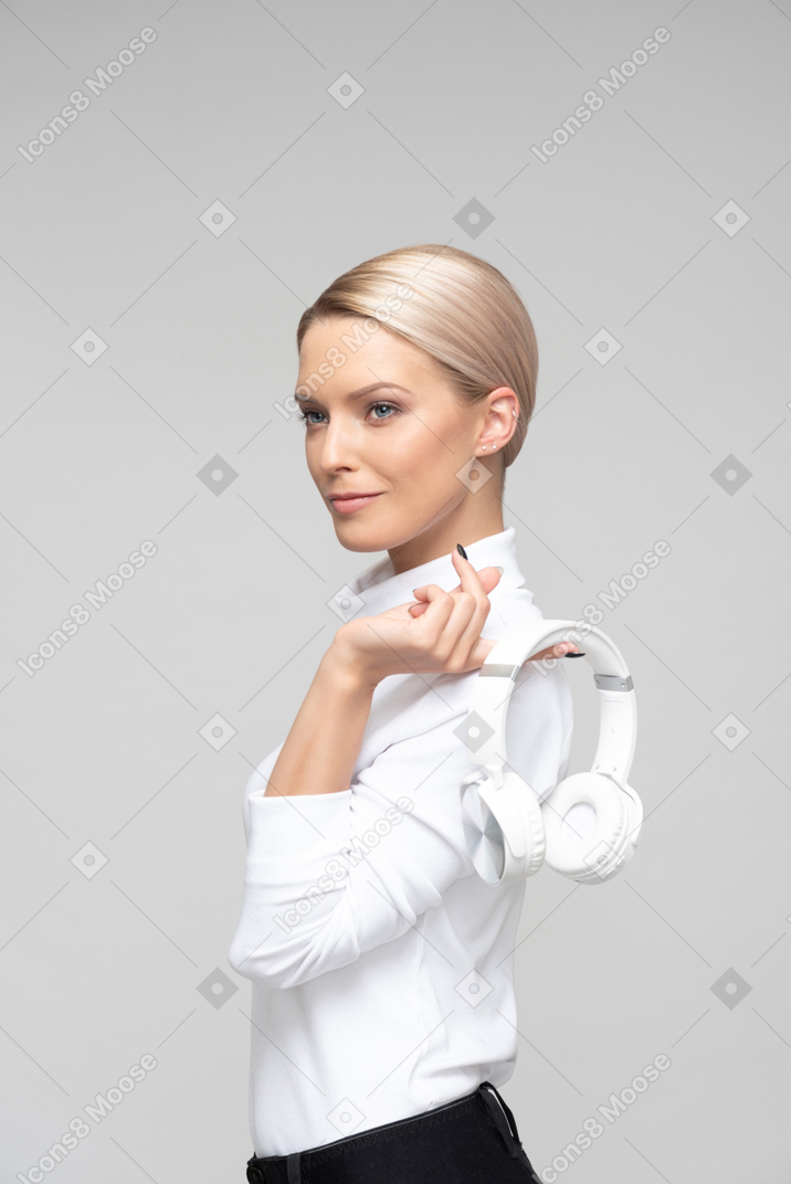 Young woman holding headphones in her hand