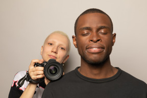 Woman behind man holding a camera