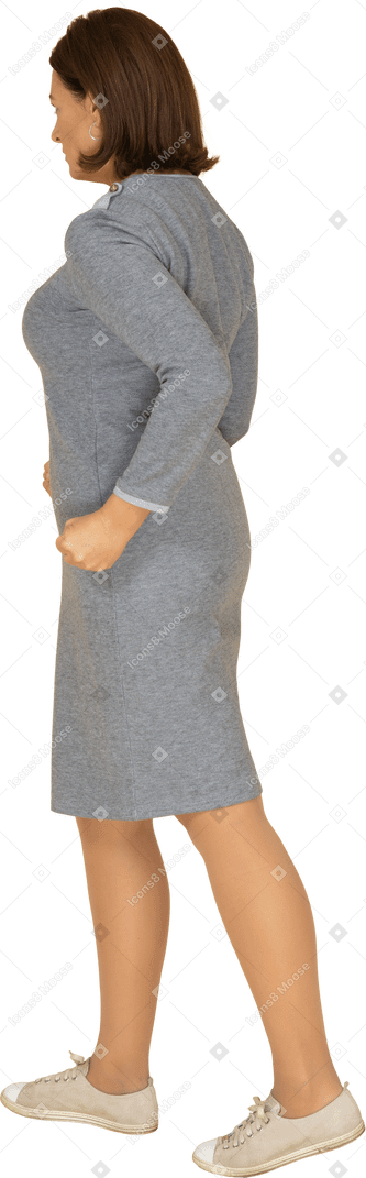Vue latérale d'une femme en colère en robe grise