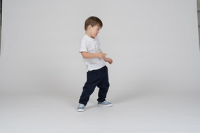 Three-quarter view of a boy leaning to the side as if dancing