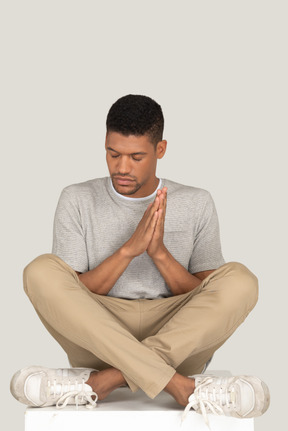 A good looking guy sitting in the lotus pose with closed eyes
