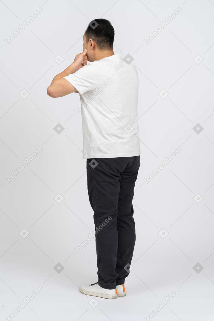 Side view of a man in casual clothes opening mouth with fingers