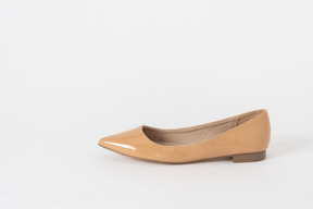 A side shot of a beige lacquer low heel shoe