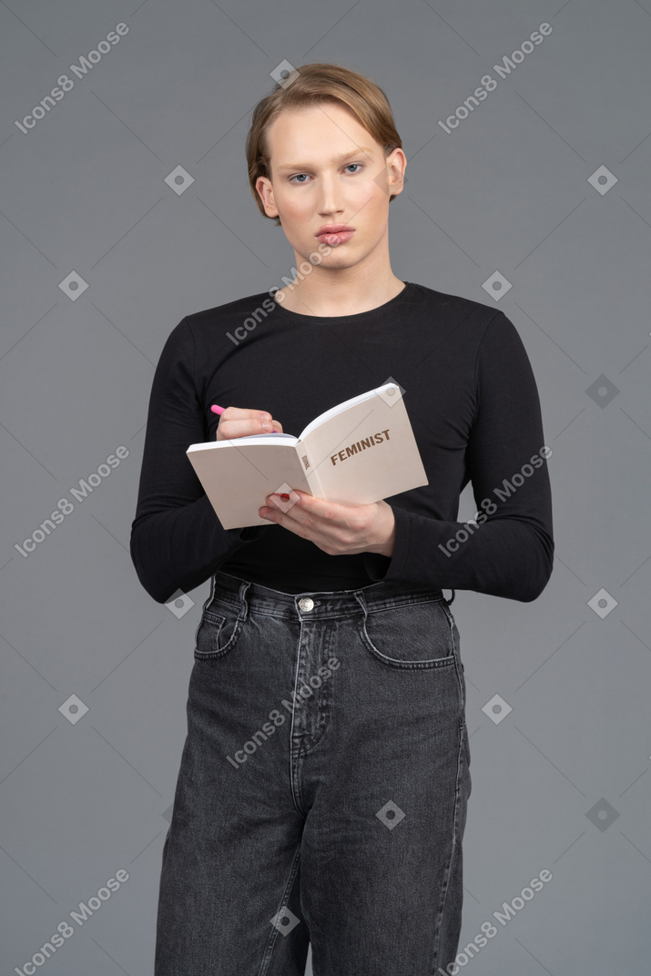 Portrait of a young person writing in a notepad