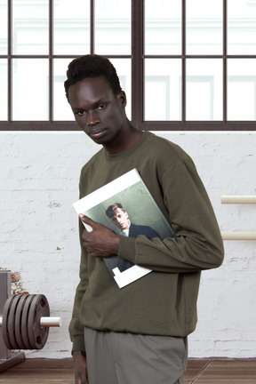 A man holding a magazine in a gym