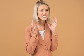 Upset young woman with raised hands