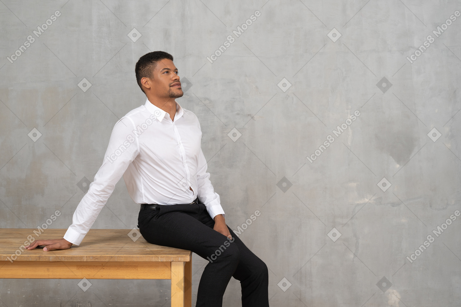 Man in office clothes sitting on a table and daydreaming