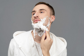 Porträt eines jungen kaukasischen mannes, der rasiert wird
