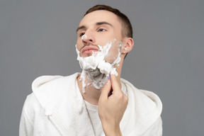 Portrait of a young caucasian man being shaved