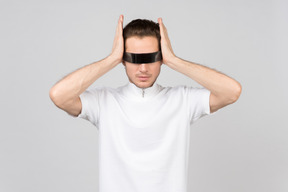Un joven con gafas futuristas sosteniendo sus sienes.