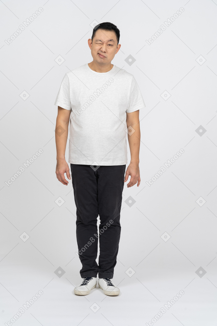 Vista frontal de um homem em roupas casuais, olhando para a câmera e fazendo caretas
