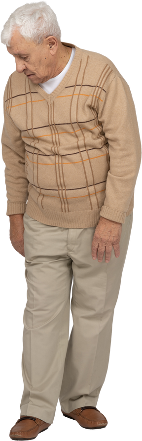 Vista frontal de un anciano con ropa informal caminando hacia adelante y mirando hacia abajo