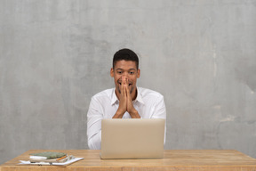 Young man covering his mouth with hands