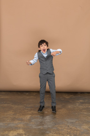 Vista frontal de um menino de terno dançando