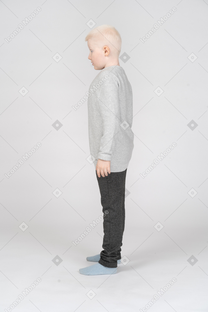 Side view of a litte boy standing still