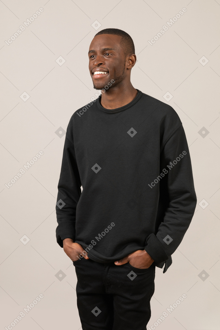 Smiling young man keeping hands in pockets