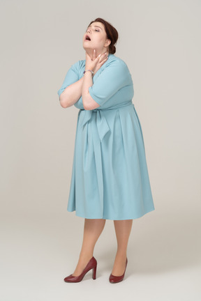 Front view of a woman in blue dress chocking herself