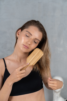 Primo piano di una giovane donna che tira fuori le doppie punte dei capelli