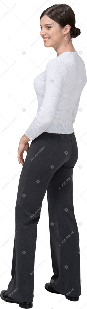 Three-quarter back view of a delighted young woman in office clothing