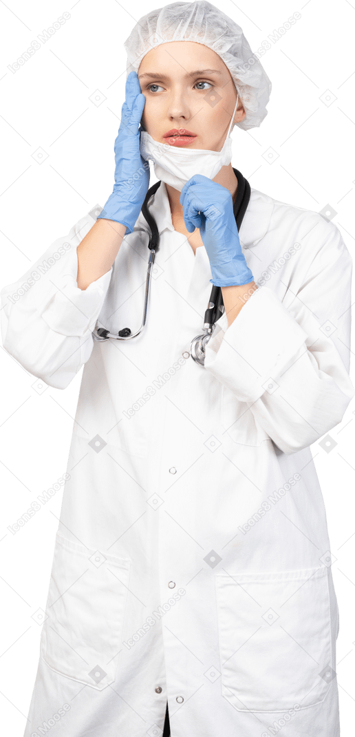 Vista frontal de una joven doctora poniéndose una máscara y mirando a un lado