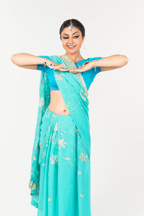 Jeune femme indienne en sari bleu debout en position de danse