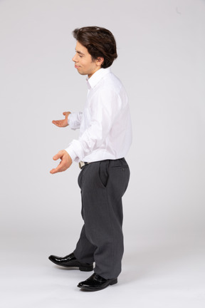 Vista lateral de um homem com roupa formal, jogando as mãos para cima