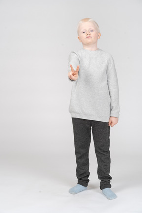 Little boy showing peace sign