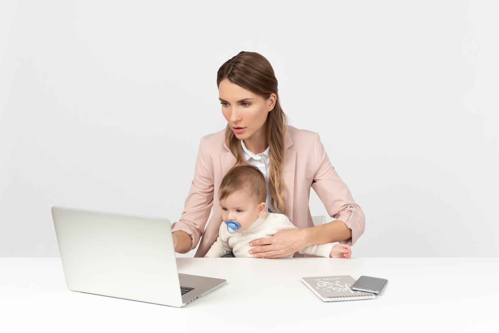 Young mom working on the computer while babysitting