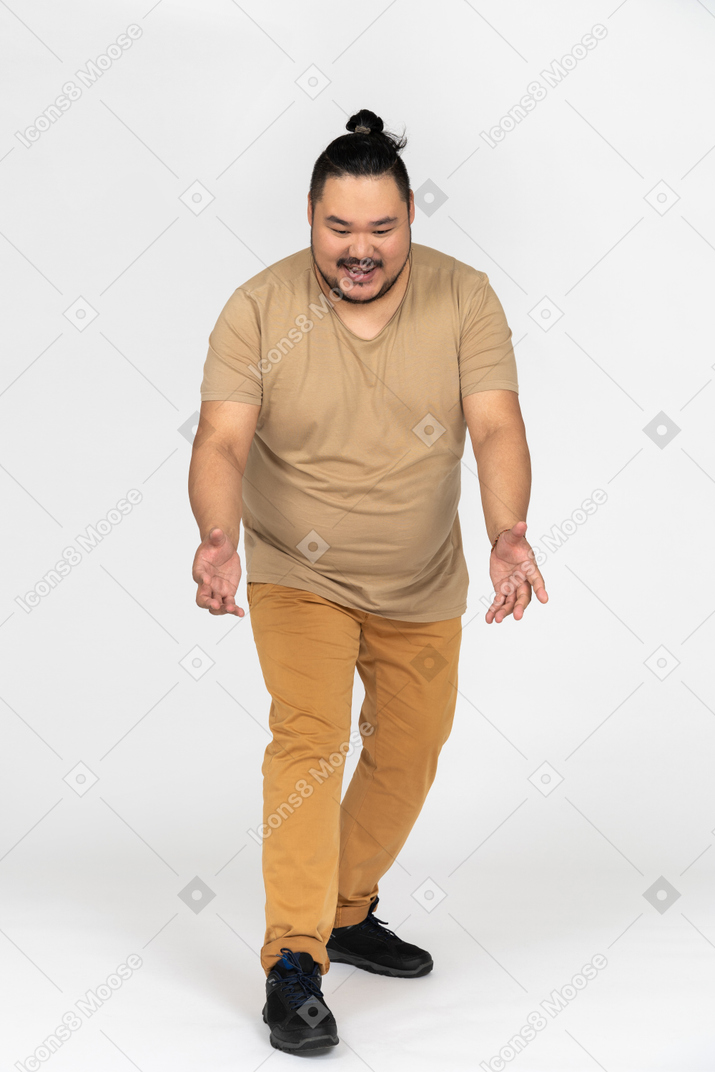 Cheerful asian man is about to lift something from the floor