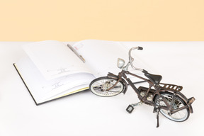 Black desk lamp, open book and toy bicycle