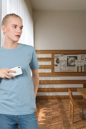 A young person in a blue t - shirt holding a cell phone