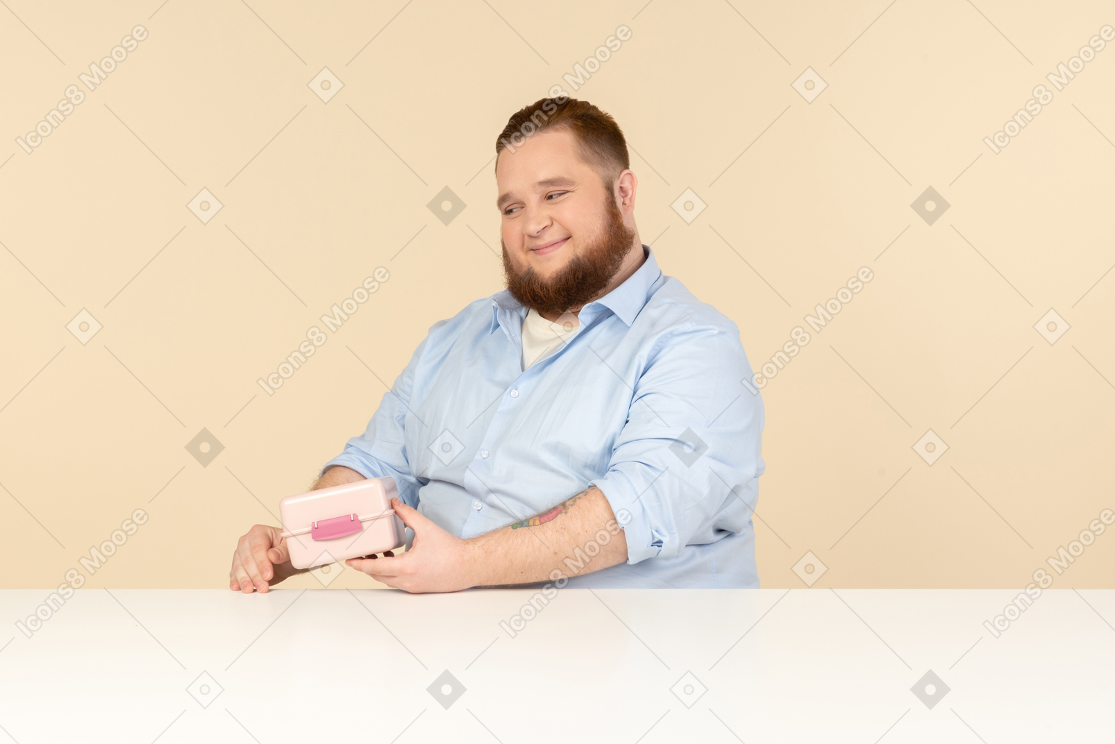 Großer mann am tisch sitzen und lunchbox halten