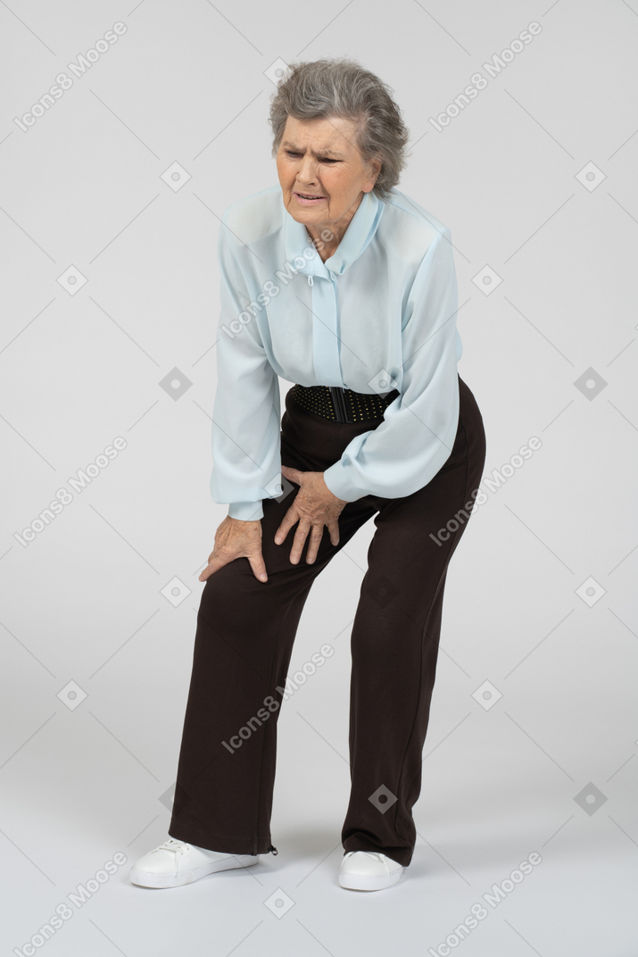 老妇人抚摸她酸痛的膝盖