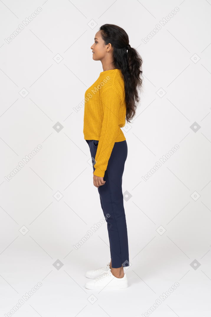 Garota feliz em roupas casuais em pé em seu perfil