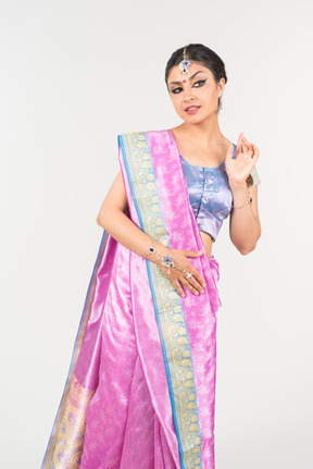 Young indian woman in purple sari standing with hands folded