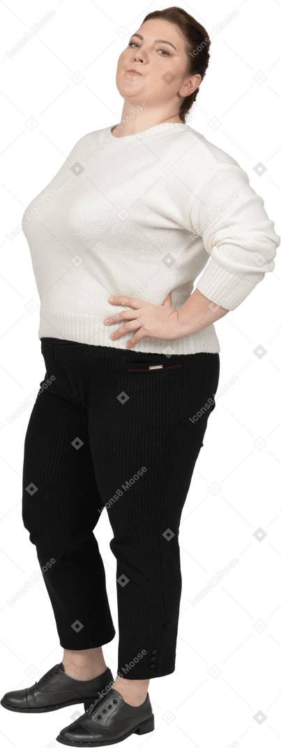 Femme dodue dans des vêtements décontractés debout avec les mains sur les hanches