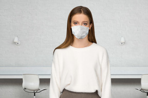 A woman wearing a face mask standing in a room