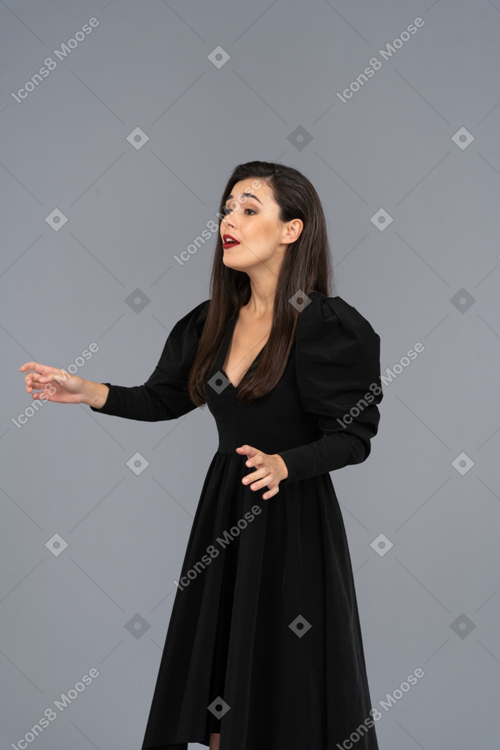 Vue de trois quarts d'une jeune femme qui chante dans une robe noire