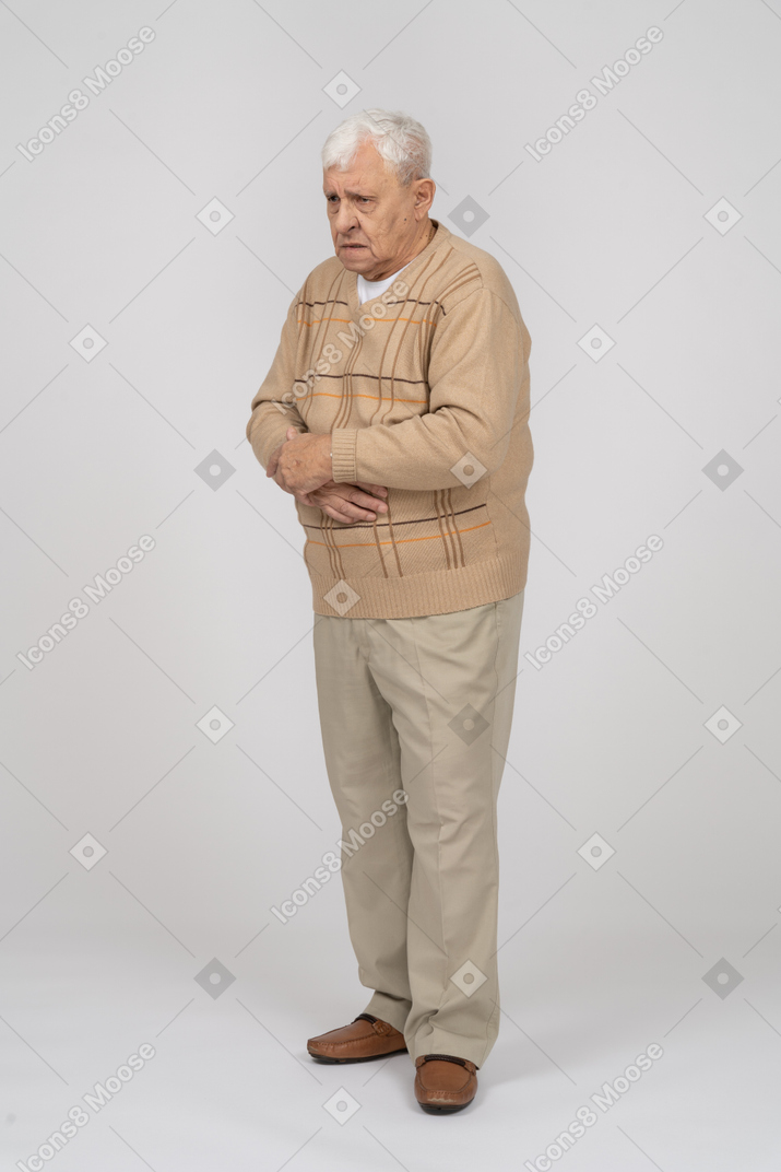 Sad old man in casual clothes standing still