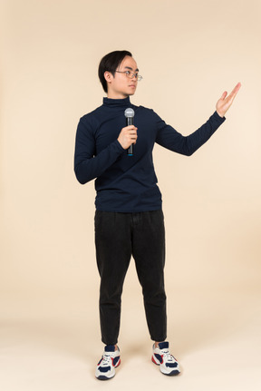 Young asian man speaking into a microphone