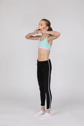 Side view of a teen girl in sportswear raising hand and arguing