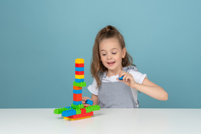 A little girl smiling and playing with building blocks