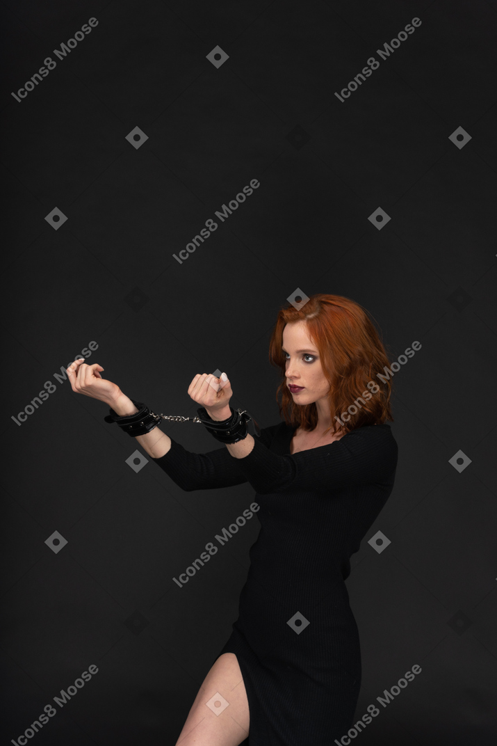 Young woman in black dress with tied hands