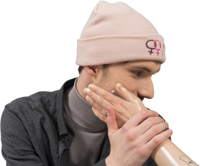 Modello maschile in cappello rosa toccato dalla mano femminile
